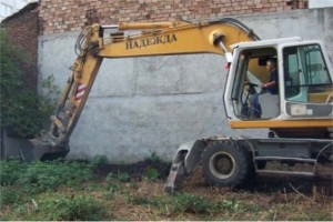 The excavator begins digging. The word on its side is “hope” in Bulgarian.